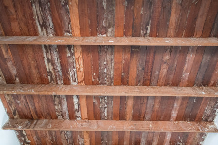 A rustic old wood ceiling with support beams inside home during major renovation project. natural grain and weathered texture of wood create warm nostalgic feelingの写真素材