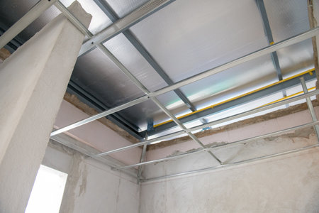 An interior renovation project showing aluminium ceiling framework and electrical wiring installation. new construction progress shows modern ceiling and room designの写真素材