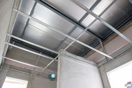 An aluminium ceiling framework during an interior renovation project. electrical wiring installation shows raw construction of building before final finishing stageの写真素材