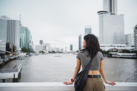 Solo southeast asian woman teenager blogger express thoughtful wait for local boat. world travel explorer cultural experience on Chao Phraya river. Asia tourism concept in Bangkok Thailandの写真素材