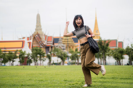 Joyful solo Southeast Asian woman teenager and blogger enjoys world travel cultural experience. happy explorer in Bangkok Thailand for local tourism concept in Asiaの写真素材