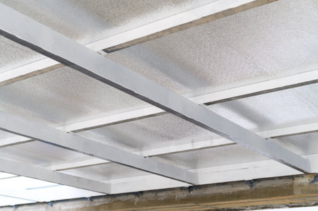Close up view of ceiling structure with metal supports and insulating sheets. These panels likely contain pu foam for energy efficiency in construction. material forms protective layerの写真素材