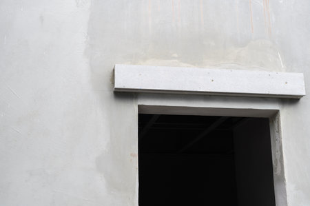 Concrete wall during house renovation shows an unfinished window and lintel. empty frame and raw material create hopeful mood for building projectの写真素材