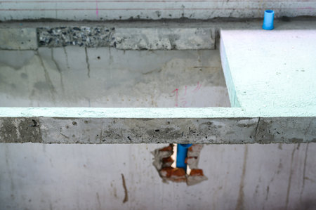 Detail of concrete foundation during house renovation. construction site shows plumbing pipe installation and repair work on floor structure for home improvementの写真素材