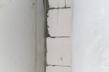 Close up of new wall during house renovation. Building with aerated concrete block and cement shows construction process and interior improvement project in progressの写真素材