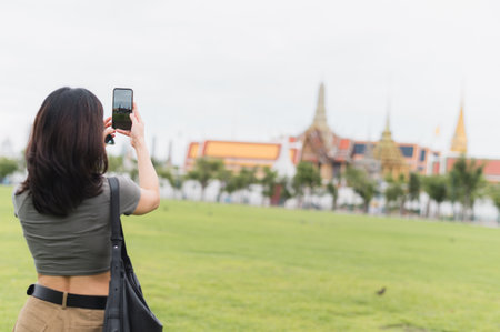 Solo southeast asian woman teenager and blogger world travel explorer take smartphone photo tourism concept for local cultural experience in Bangkok Thailand asiaの写真素材