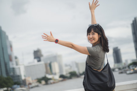 Happy solo young southeast asian woman teenager blogger world travel tourism. Local cultural experience concept for an explorer Bangkok Thailand by Chao Phraya river with smartphone for asiaの写真素材