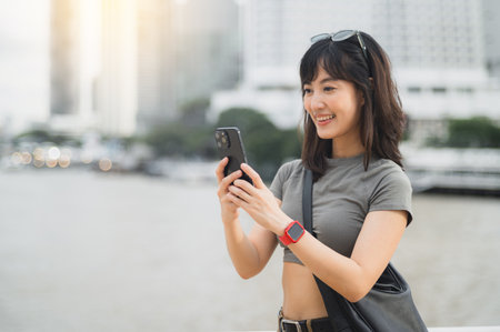Young southeast asian woman teenager blogger using smartphone searching travel guide. World travel...