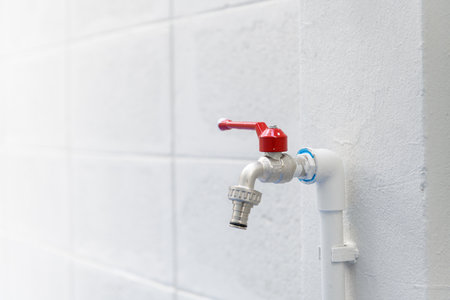 Close up detail of new water tap during house renovation project. simple plumbing construction on white tile wall shows clean and practical installationの写真素材