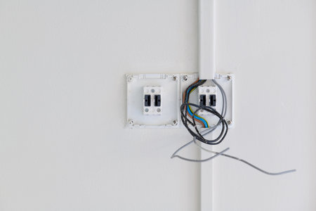 Closeup detail of an unfinished electrical switch installation during house renovation. exposed wire...