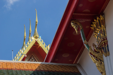 The roof with ornemental roof points shaped like the head of the Garuda and toothlike ridges on the sloping edges of a gable, representing the fin on the back of Naga of Pho Temple, Bangkok, Thailandの写真素材