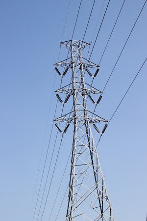High voltage post with blue sky background.の写真素材