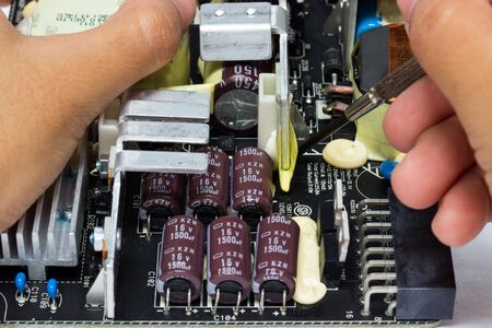 Electronic technician operates with circuit board.の写真素材