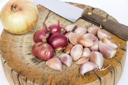 Red onions, garlics and onions set on the chopping block with knife to make soup and fried delicious recipes, ingredient in Thailandの写真素材