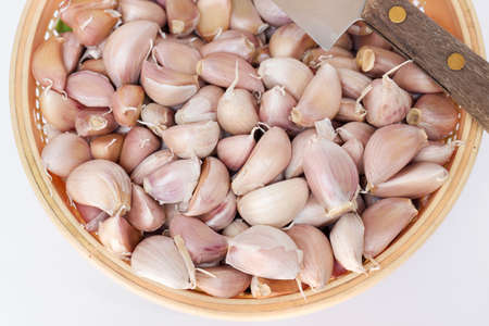 Basket of fresh garlic clove with knifeの写真素材