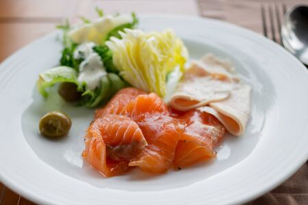 Smoked salmon with salad and green olives.の写真素材