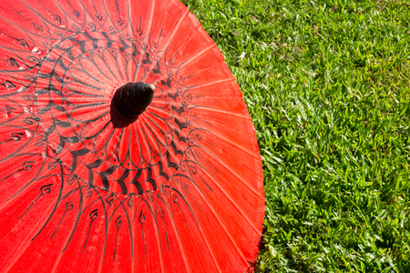 Colorful umbrellas on grass field ; Bo-sang umbrella handicraft made from paper of Chiang Mai, Thailand.の写真素材
