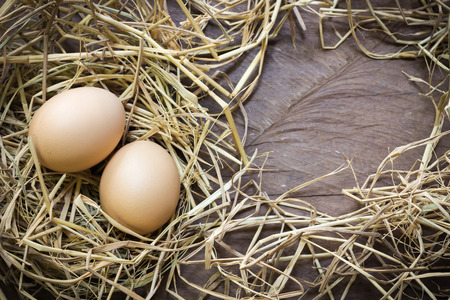 Eggs with rice straw on wooden background with copy space, Top view, Still lifeの写真素材