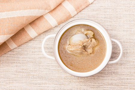 Bowl of pork bone soup with herbs on gray table matの写真素材