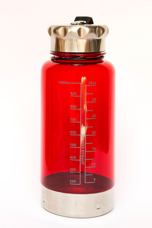 Red bottle scale measuring the volume of water isolated on white backgroundの写真素材