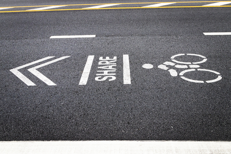 The symbol of the bike lane on the street. Sign on the cycling way meaning please share lane for bikers.の写真素材