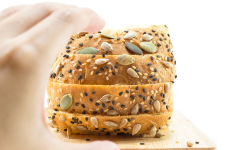 Fresh sliced bread with sunflower and sesame seeds; hands hold concept.の写真素材