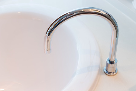 Bathroom interior in cozy colors and faucet with bathtubの写真素材