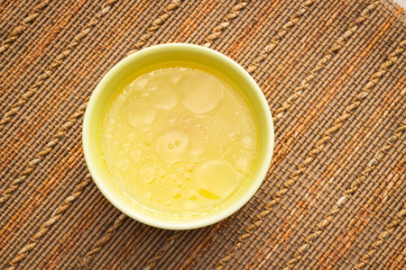 Bowl of chicken broth on rural tableの写真素材