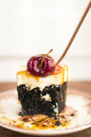 Dark beer chocolate cake (Chocolate Stout Cake) with caramel sauce and juicy fruits on top.の写真素材