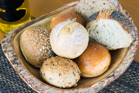 Fresh homemade bread in wooden basket with olive oil and balsamic vinegarの写真素材