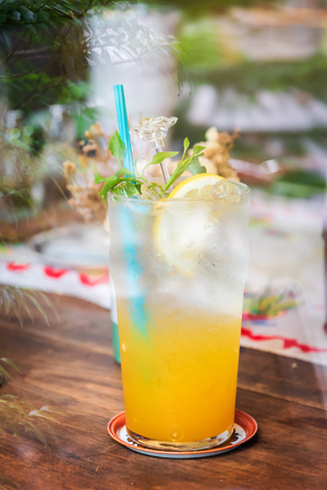 Summer drink; fresh citrus and lime with honey juice on ice in glass; shot through window glass.の写真素材