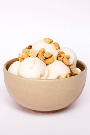 Coconut ice cream with nuts in small bowl isolated on white backgroundの写真素材