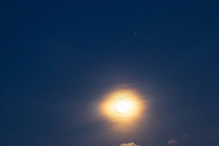 Full moon shining glowing light through a twilight sky with star. Long exposure for beautiful nature...