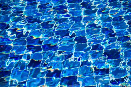 Blue water ripple background with sun reflectionsの写真素材