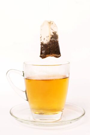 Tea bag dipped in the cup with hot water isolated on white backgroundの写真素材