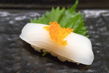 Squid sushi with Tobiko (Flying fish roe) on top.の写真素材