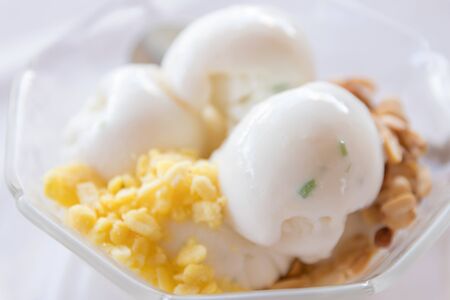 Coconut ice cream with nuts in glass bowl.の写真素材