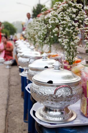 Line up rice in silver bowls sets of alms prepared for buddhist monk in morning at Sangkhlaburi Mon Village, Kanchanaburi, Thailand.の写真素材