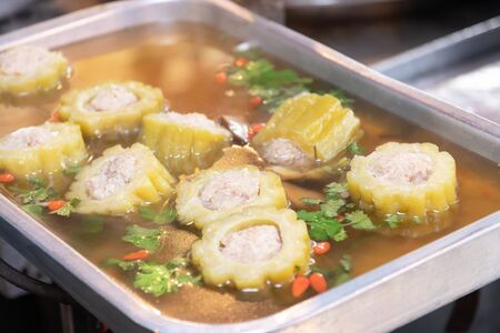 Bitter gourd soup with pork ribs in tray on stove to sale in market.