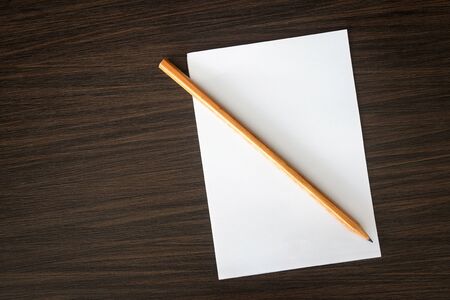 Blank notepad and pencil on wooden tableの写真素材