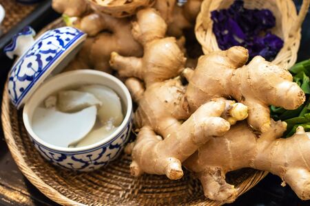 Fresh ginger on weave threshing basket ingredients used in herbal medicine.の写真素材
