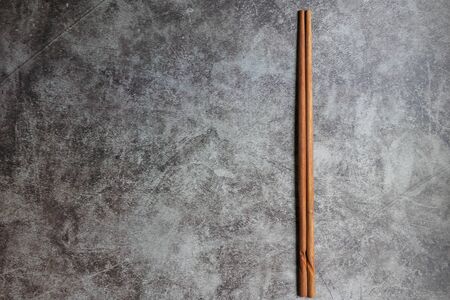 Wooden chopstick isolated on grey vintage background with copy space.の写真素材