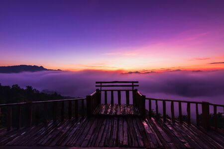 The beautiful early morning sky with twilight and waves of fog at wooden terrace of Baan Ja Bo village viewpoint Pang Mapha, Mae Hong Son, Northern Thailand.の写真素材