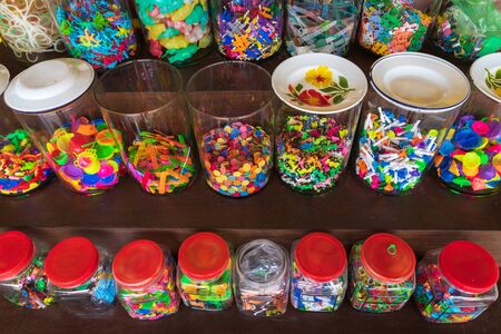 Colorful vintage plastic toys in a glass jar.