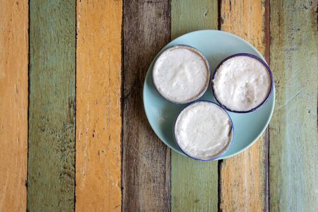Streaming coconut milk custard in small porcelain cup. Thai dessert.
