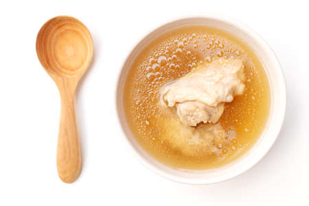Bowl of pork bone soup with wooden spoon isolated on white background.の写真素材