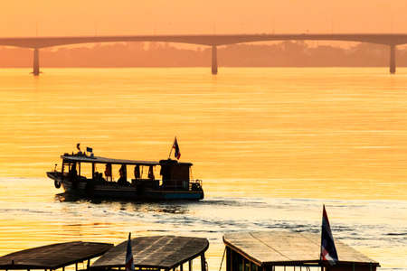 Silhouette boats in the river with beautiful sunset at Mekong river, Nong Khai in Thailand and the first ThaiâLao friendship bridge on background.の写真素材