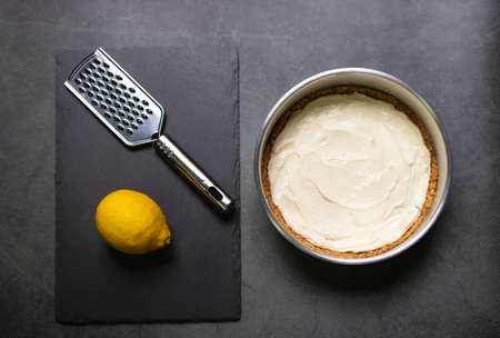 Baking ingredients for honey lemon cheese pie and lemoncurd on black table background.の写真素材