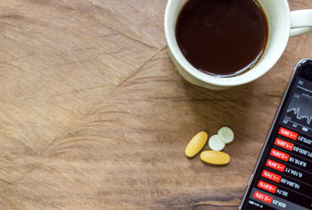 Black coffee and aspirin with a bad news in the morning. Stock market crash, analysis of the market data on smartphone.の写真素材