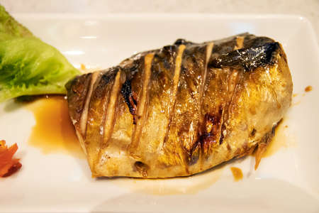 Grilled Saba fish on white plate; easy meal with healthy food.の写真素材